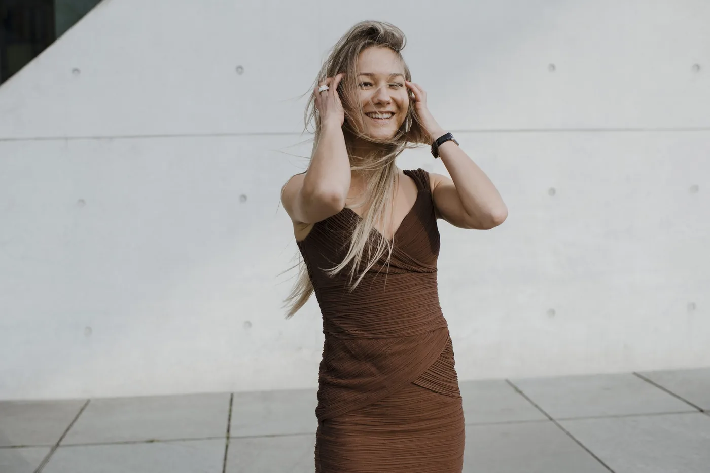 Kristina Hagewald auf einer Treppe vor heller Betonarchitektur